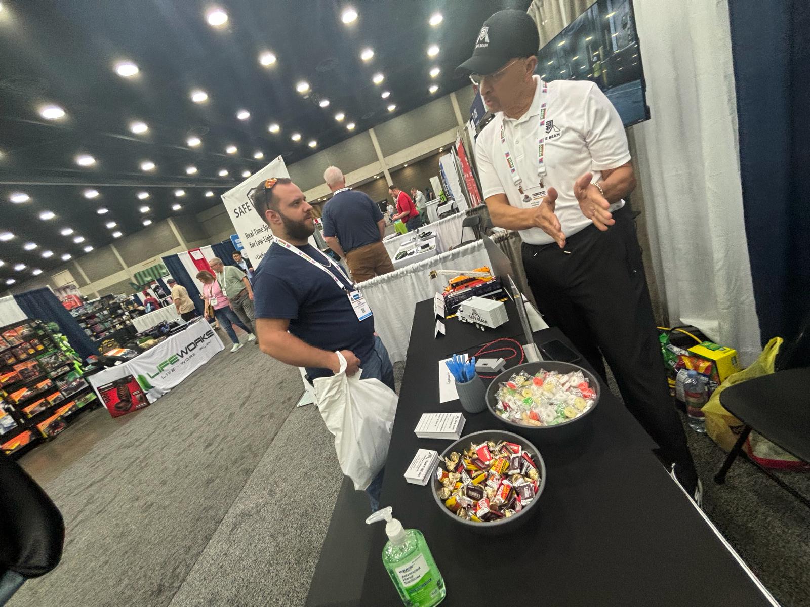 SafeBeam representative walking an attendee through the product at MATS